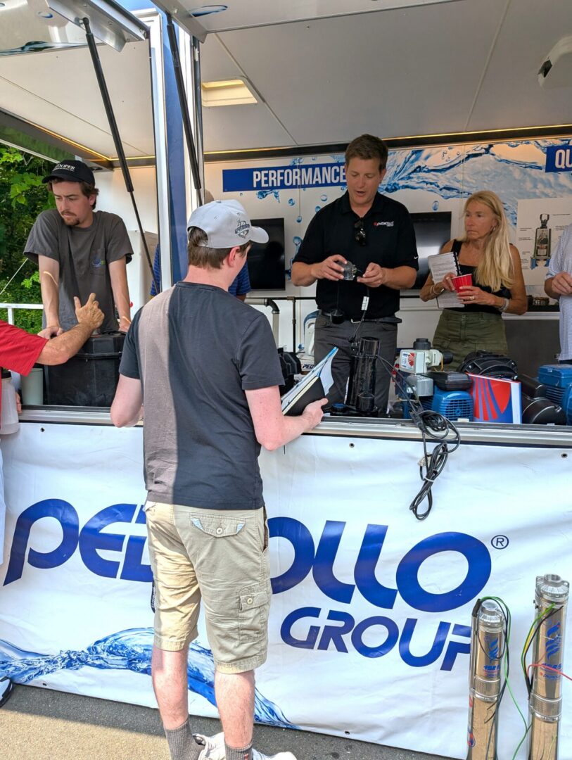 People at outdoor demonstration booth examining products